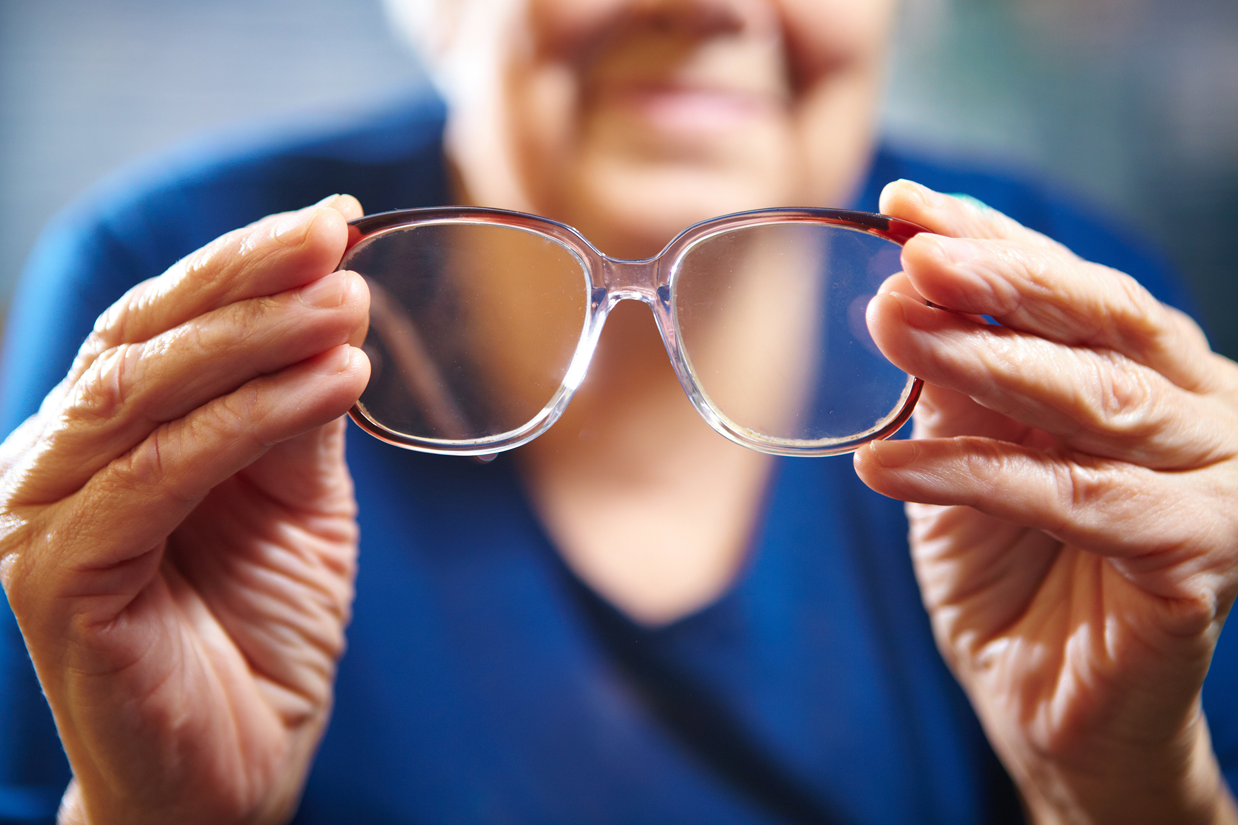 Old woman hands with eyeglasses